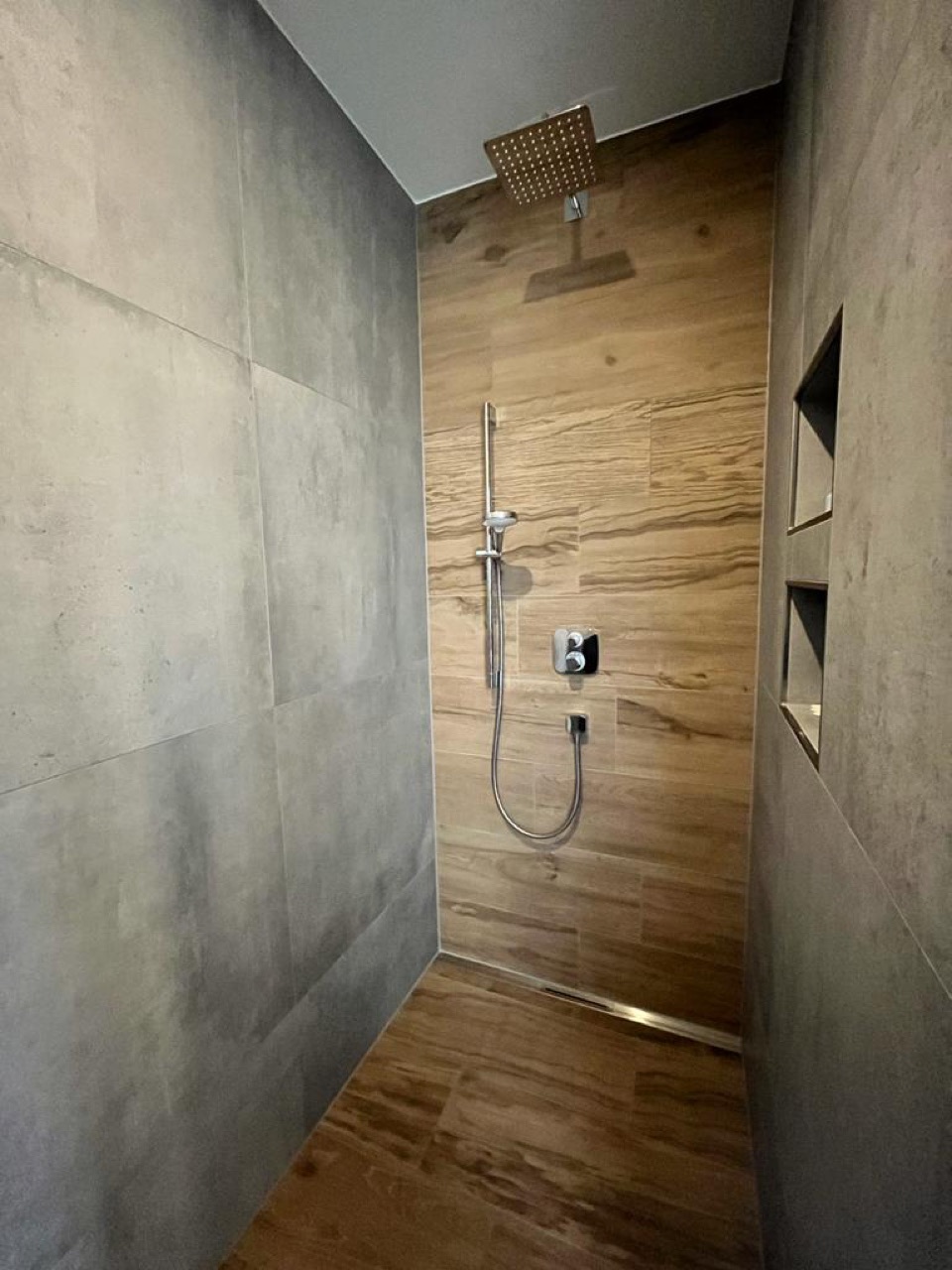 Dusche mit Wandfliesen in Holzoptik und Betonoptik