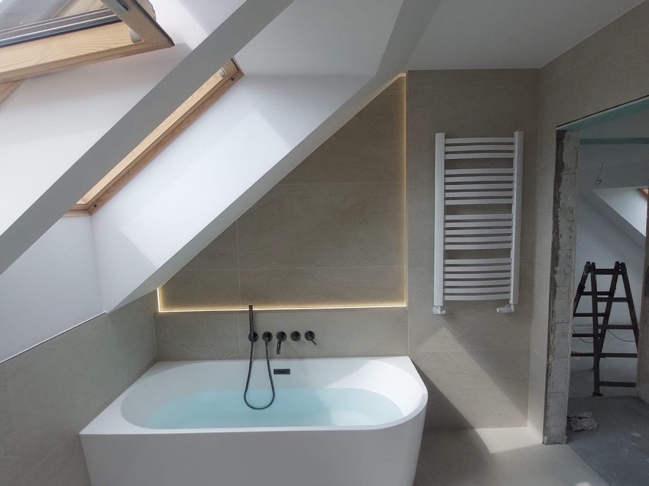 Dachbad mit Wanne und beleuchtetem Spiegel