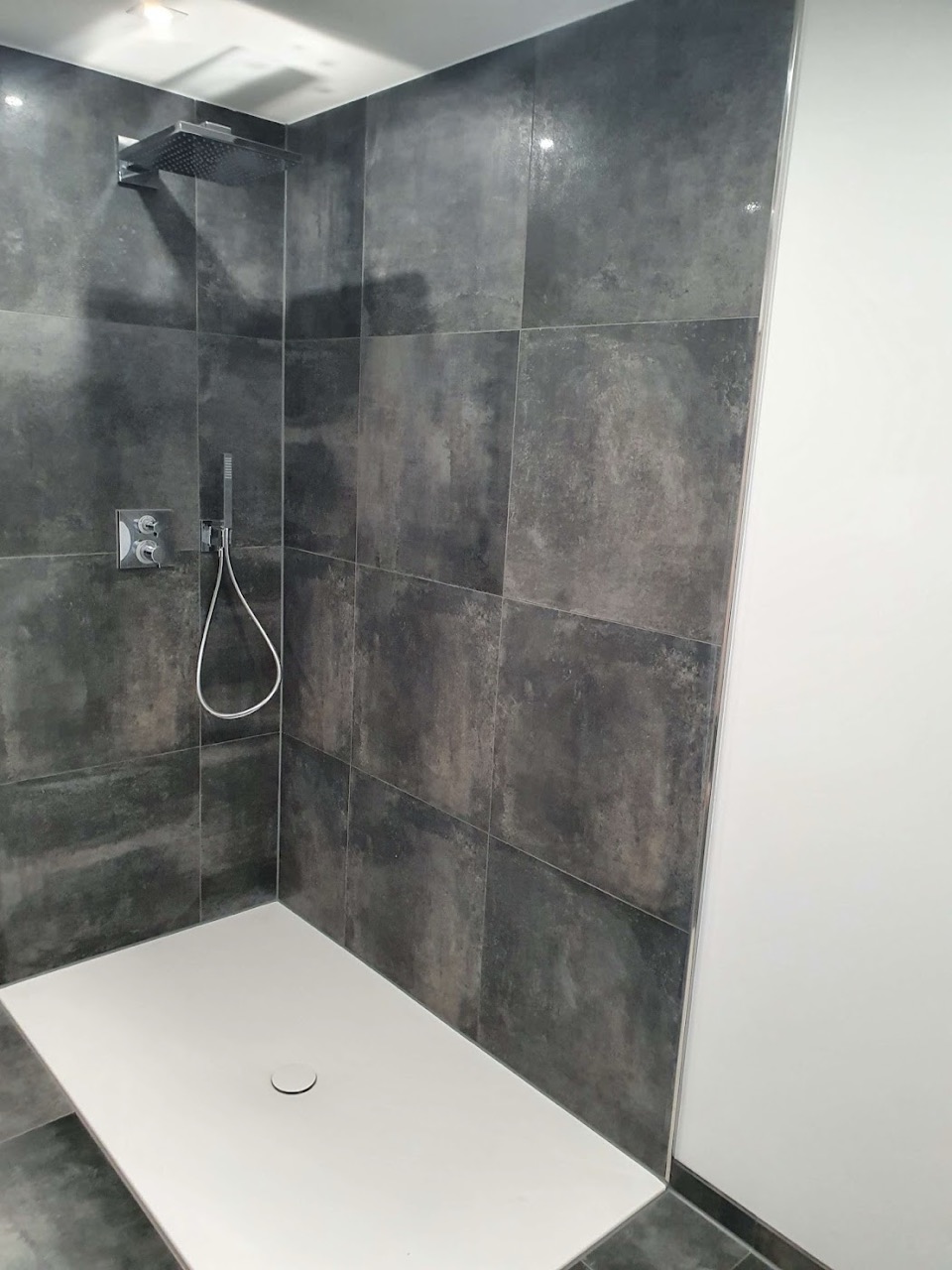 Dusche mit dunklen Wandfliesen im Großformat
